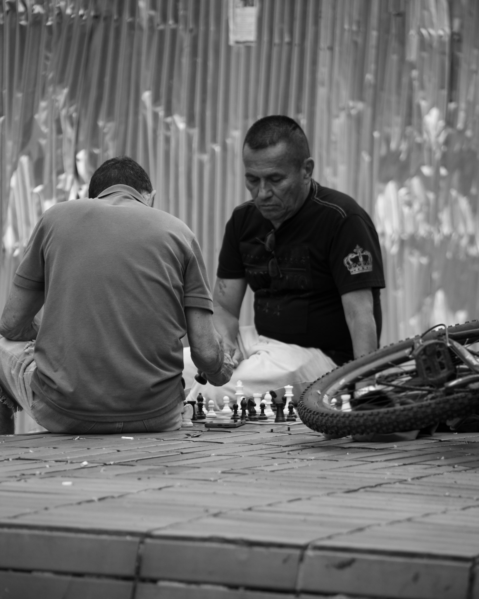 Comunidad jugando ajedrez sobre muro de ladrillos